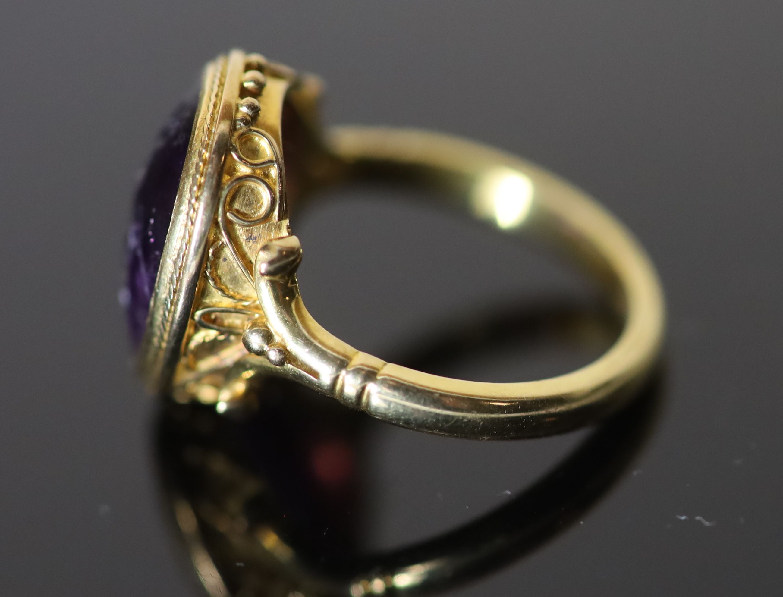 A 19th century style gold ring set with an antique intaglio oval amethyst,